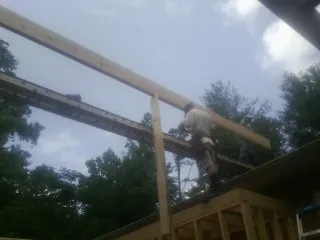 Carpenter setting a ridge beam over a new addition frame — Ice Dam Removal by Roofing Brothers in Grantsville
