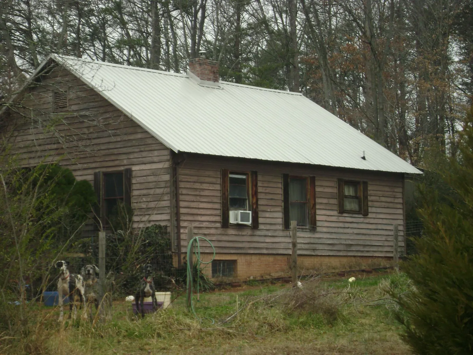 White metal roof on an old wood sided farmhouse, from a Metal Roof Installation job in Grantsville